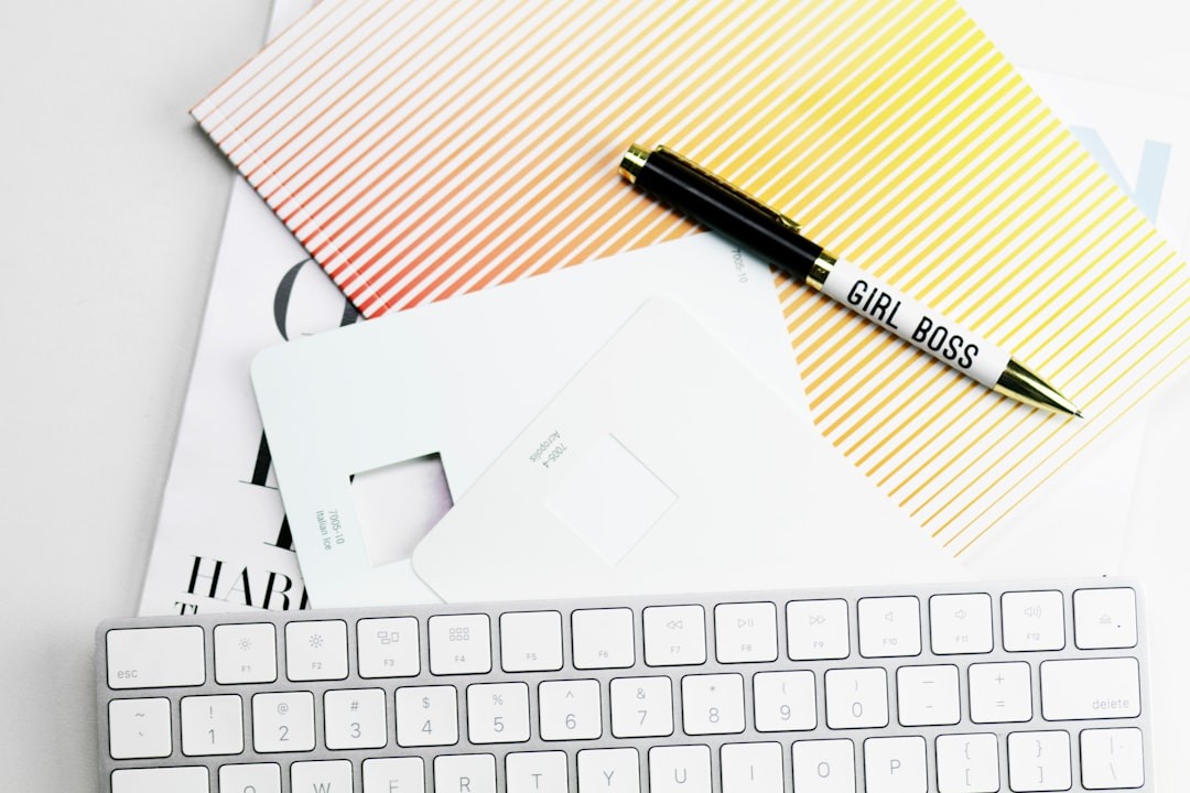 Apple Magic Keyboard, papers, and pen on white surface